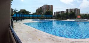 duży niebieski basen w budynku w obiekcie Apto en conjunto cerrado con piscina. w mieście Ricaurte