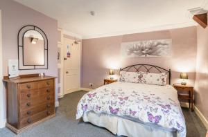 een slaapkamer met een bed, een dressoir en een spiegel bij Yallands Farmhouse in Taunton