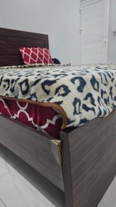 a bed with a black and white blanket on it at Luxury Hotel Rooms in Karachi