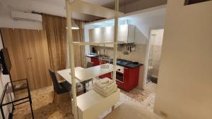 una cucina con bancone bianco e armadi rossi di Sergio's Rooms & Studio close Tiburtina Station a Roma