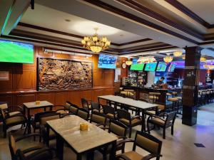 un restaurante con mesas, sillas y TV en The Pattaya Sports Hub en Pattaya Central