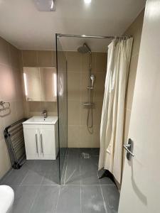 a bathroom with a shower and a sink at The Chapter- Knightsbridge Suites in London