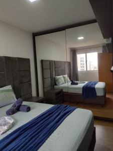 a bedroom with two beds and a large mirror at Apto Brilho do Sol - Barra Velha - SC in Barra Velha +27 photos