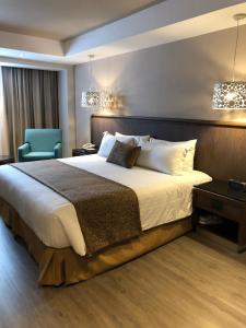 1 dormitorio con 1 cama grande y 1 silla azul en Hotel Metropol, en Ciudad de México