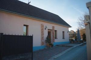 a white house with a black fence in front of it at Ubytovanie Nitrianske Pravno in Prievidza