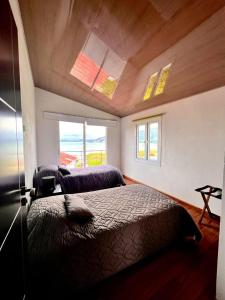 a bedroom with two beds in a room with windows at Cabañas Big Day Lago de Tota in Aquitania