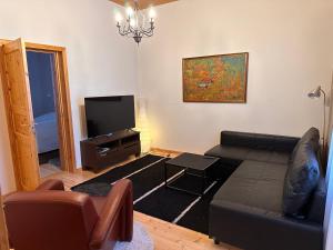 een woonkamer met een bank en een flatscreen-tv bij Liepeen pappila in Pudasjärvi