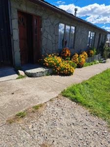 une maison fleurie devant un bâtiment dans l'établissement Hostal Boutique "Maryluz", à Coyhaique