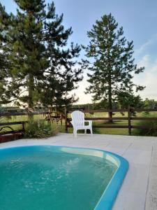 a white chair sitting next to a swimming pool at La Cipriana in Concepción del Uruguay +75 photos