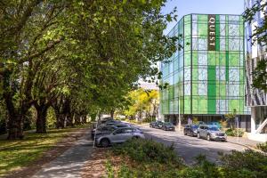 eine Straße mit Autos, die vor einem Glasgebäude geparkt sind in der Unterkunft Quest on Cambridge in Christchurch