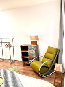 ein Schlafzimmer mit einem grünen Stuhl und einer Kommode in der Unterkunft The Barts Apartments - Self Check-in in Wien