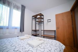 a bedroom with a bed with towels on it at Zlaribor Breza 5 in Čajetina