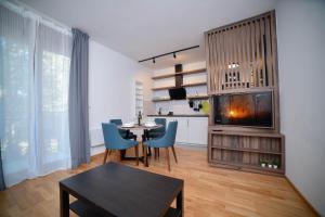 a living room with a table and a fireplace at Zlaribor Breza 5 in Čajetina