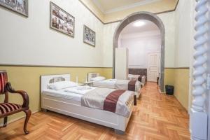 two beds in a room with an archway at Unio Apartment in Budapest