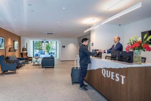 two men standing at a hotel reception counter at Quest on Cambridge in Christchurch