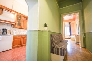 a kitchen with green walls and a bench in it at Unio Apartment in Budapest