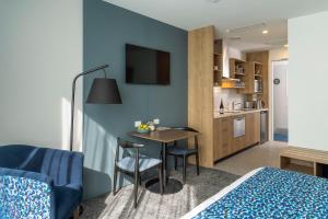 a room with a bed and a table and a kitchen at Quest on Cambridge in Christchurch