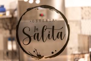 una señal para una tienda satta se ve en una ventana de la tienda en LOCANDA LA SALITA, en Monforte dʼAlba