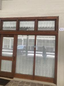 a glass door with a reflection of a person in the window at Bilocale a Mazzin in Campestrin