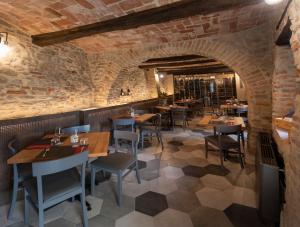a restaurant with tables and chairs and a brick wall at LOCANDA LA SALITA in Monforte dʼAlba