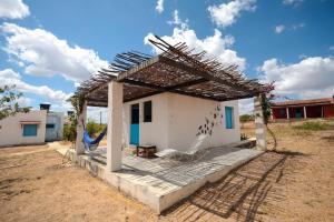 a house with a pergola and a chair at Fazenda Poço das Pedras in São João do Cariri