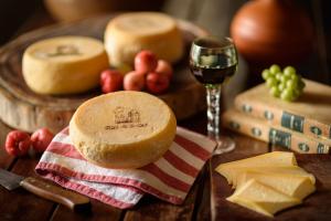 a table with bread and cheese and a glass of wine at Fazenda Poço das Pedras in São João do Cariri