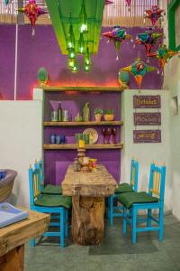 una mesa y sillas en una habitación con una pared púrpura en La Casa Azul, en Morelia