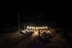 a group of people standing in front of a group of lights at Fazenda Poço das Pedras in São João do Cariri