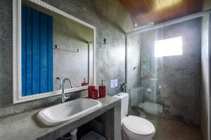 a bathroom with a sink and a toilet and a mirror at Fazenda Poço das Pedras in São João do Cariri