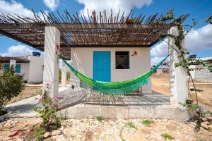 a house with a hammock in front of it at Fazenda Poço das Pedras in São João do Cariri