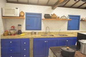 a blue kitchen with two sinks and a microwave at Fazenda Poço das Pedras in São João do Cariri