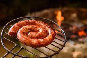 two sausages cooking on top of a grill at Fazenda Poço das Pedras in São João do Cariri