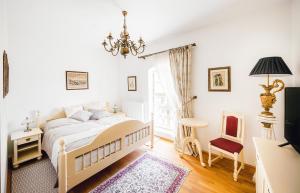 a bedroom with a white bed and a chandelier at Château Rychvald in Ostrava