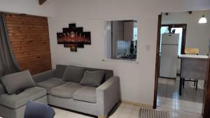 uma sala de estar com um sofá e uma cozinha em CABAÑA CASA DE PIEDRA em San Carlos de Bariloche