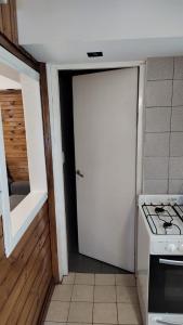 uma porta branca numa cozinha com um fogão em CABAÑA CASA DE PIEDRA em San Carlos de Bariloche