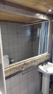 a bathroom with a mirror and a sink at CABAÑA CASA DE PIEDRA in San Carlos de Bariloche
