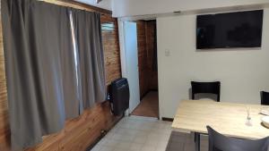 une salle à manger avec une table et une télévision dans l'établissement CABAÑA CASA DE PIEDRA, à San Carlos de Bariloche