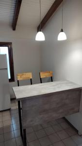 - une table dans une cuisine avec deux chaises et deux lumières dans l'établissement CABAÑA CASA DE PIEDRA, à San Carlos de Bariloche