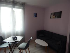 a living room with a couch and a table at Le jardin d'eden in Lourdes