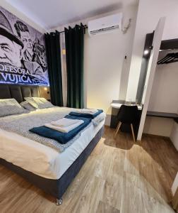 a bedroom with a large bed and a desk at Magazaki Apartments Tešnjar in Valjevo