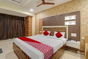 a bedroom with a large bed with red pillows at OYO Flagship Hotel Aditya Grand Inn in Guntūr