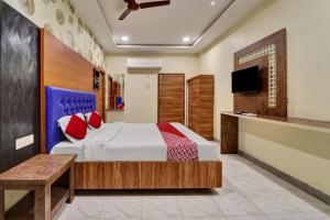 a bedroom with a bed and a tv at OYO Flagship Hotel Aditya Grand Inn in Guntūr