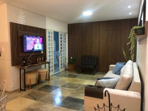 uma sala de estar com um sofá e uma televisão de ecrã plano em Próximo ao centro, perto de tudo! em Belo Horizonte
