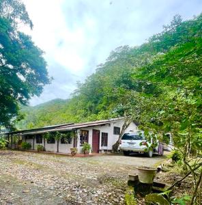 Río Negro的住宿－Finca Mamatoya 1 Río Negro，前面有停车位的房子