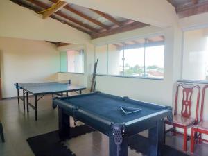 two ping pong tables in a room with two chairs at Recanto Solarium in Itanhaém