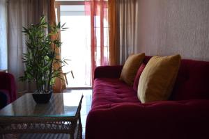 a red couch with yellow pillows in a living room at White Hills Apartments in Budva