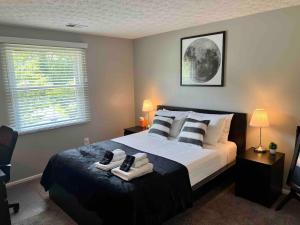 a bedroom with a bed with two pairs of shoes on it at Holly Oaks in Columbus