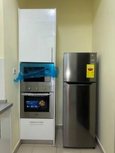 a kitchen with a stainless steel refrigerator and an oven at Cozy Luxe Apartment w/ WiFi & AC in Tema