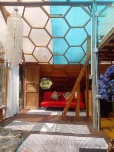 a room with a red couch and a glass ceiling at Ecocasa del Encuentro: única y confortable in La Calera