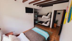 Cette petite chambre comprend un lit et une télévision. dans l'établissement Hotel Ficus Villa de Leyva, à Villa de Leyva